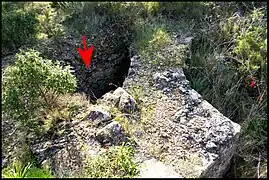 Fig.8 - Autre vue partielle de la pièce 7, avec le mur en abside et le réduit (flèche).