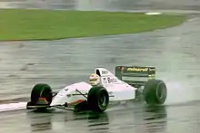 Photo d'une monoplace blanche sur une piste détrempée