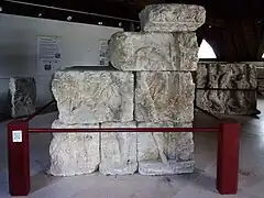 Photographie en couleurs d'un assemblage de blocs sculptés représentant un personnage.