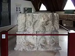 Photographie en couleurs d'un assemblage de blocs sculptés représentant des personnages.