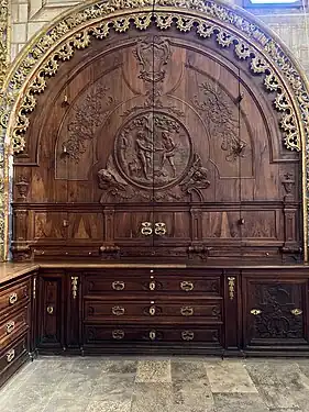 Placard sculpté à droite du retable au fond de la sacristie.