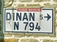 Plaque Michelin scellée le mur d’une maison.