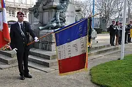Porte-drapeau du 9e&nbsp;régiment de chasseurs parachutistes devant le monument aux morts de Laval (mars 2012).