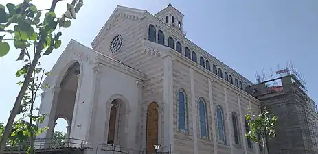 Façades principale et droite d'une église inachevée.
