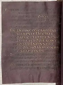 Parchemin manuscrit de couleur pourpre et aux lettres dorées.