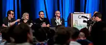 Photographie de plusieurs personnes attablées et répondant à des questions sur la scène d'une salle de convention. Phil Fish y apparaît comme un jeune homme blanc portant des lunettes.