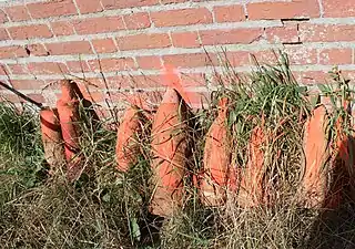 Obus potentiellement dangereux déposés contre le mur du cimetière en attente de leur enlèvement en août 2022.