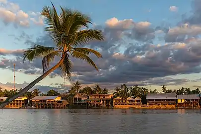 Rive de l'île de Don Khon avec maisons en bois sur pilotis et nuages colorés, depuis Don Det