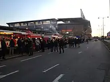 Photographie présentant des stands de vente et des personnes le long d'une rue.