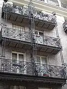 Balcons d'un immeuble rue des Bernardins à Paris : les deux moitiés sont séparées par une herse.