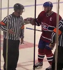 Photo de Saku Koivu dans la tenue des Canadiens de Montréal qui discute avec un arbitre.