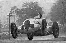 Photo d'une voiture lancée à pleine vitesse et décollant des quatre roues.