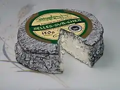 Vue d'un fromage cendré à croute molle blanche.