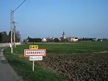 Entrée par la route départementale 417 et le centre du village au second plan