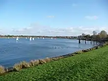 Photo d'un plan d'eau sur lequel voguent plusieurs petits bateaux à voile