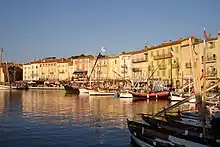 Bâtiments au bord de l'eau devant lesquels sont amarrés des bateaux.
