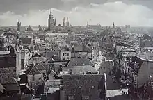 Photographie noir et blanc d'une ville, vue aérienne en contre-plongée.