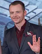 Photographie d'un homme levant légèrement les mains.