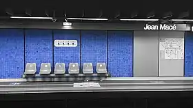 Un quai de la station en 2021 : carreaux bleus ornant les murs et sièges gris.