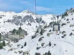 Photographie de Plan-Bouchet avec une cabine devant, le paysage étant enneigé.