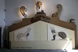 Photographie en couleurs montrant des vestiges de décors antiques replacés dans leur contexte architectural.