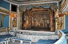 La salle de théâtre aux sièges de velours bleu.