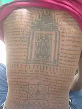 Tatouage traditionnel d'Asie du Sud-Est appelé sak yant, réalisé dans le dos d'un homme.