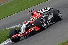 Photo d'une monoplace rouge et grise en piste