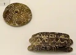 Fusaïole (en haut - décoration rappelant les lignes ambulacraires d'un test d'oursin) et navette (en bas) en terre cuite, Knossos, ~5 800–4 500 ans B.C. (Néolithique). Musée archéologique d'Héraklion, Crète, Grèce