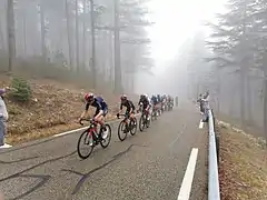Rythme imposé par l'équipe Inéos en tête de peloton dans la montée vers le Chalet Reynard, dans le brouillard à environ 7&nbsp;km de l'arrivée.