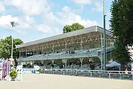 Tribune à deux niveaux où sont assis les spectateurs