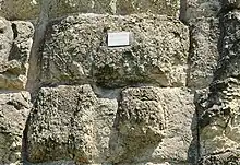 Photographie en couleurs d'un mur en gros blocs de peirre équarris.