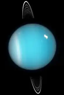 Deux images d'Uranus montrant de grands arcs partant de son équateur jusqu'à loin au-dessus de ses pôles, un nuage est très visible dans l'hémisphère Nord.