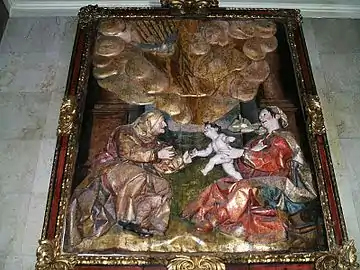 Bas relief émaillé représentant deux femmes assises côte à côte entre lesquelles s'élance un bébé.