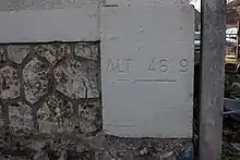 Une inscription au bas d'un mur d'un bâtiment indiquant l'altitude de 46,9 m