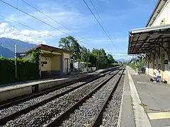 Vue d'ensemble des voies et des quais reliés par un passage pour les piétons.