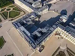 La cour de Marbre (pavée noir et blanc) est dans l'ombre.