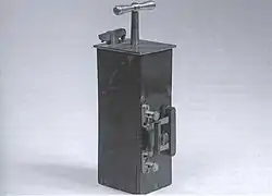 Photo d'une boite rectangulaire d'où dépasse une poignée.