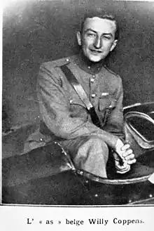 Photographie noir et blanc d'un homme accroupi et posant dans le cockpit ouvert de son avion.