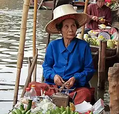 Vendeuse d'un marché flottant, le Damnoen Saduak Floating Market&nbsp;(en).