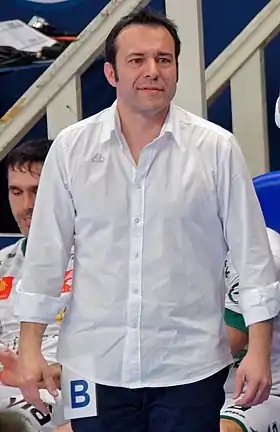 Photographie en couleur d'un homme de profil en chemise blanche.