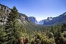 Photographie d'un paysage de haute montagne et d'une vallée entourée de falaises de granit